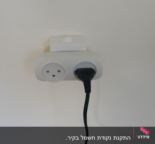 שקע חשמל עם תקע מחובר לקיר